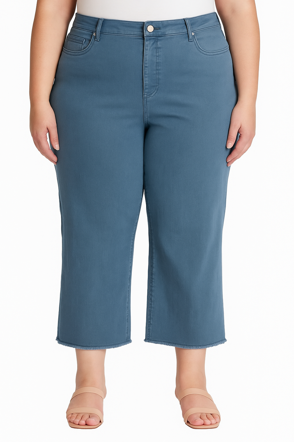 Plus-size model wearing slate blue tummy tuck cropped jeans with fray hem and shaping waistband, front view