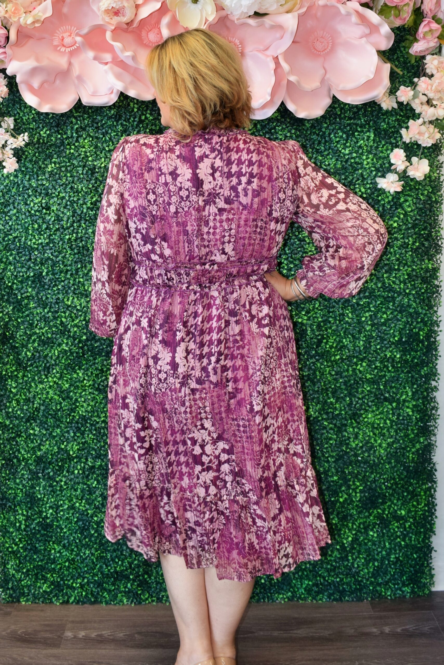 Woman wearing the Evangeline plum chiffon lurex midi dress with long sleeves and V-neckline, perfect for weddings or holiday parties. Back Side.