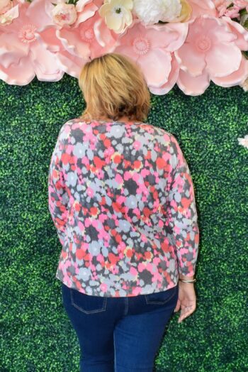 back side Plus size woman wearing Dear Scarlett floral henley hacci top in vibrant pink, coral, berry, and gray print – soft, wrinkle-free knit.