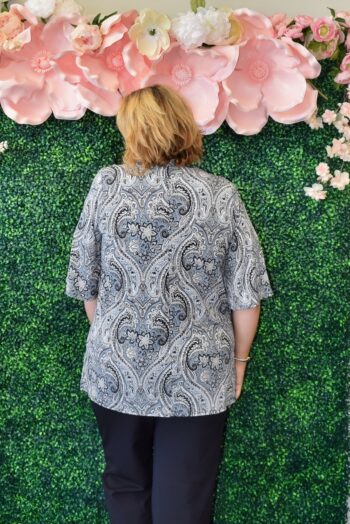 Back view of a plus-size model wearing the Dear Scarlett Plus Size Paisley Open-Front Kimono Cardigan. Features a lightweight, wrinkle-free fabric, half sleeves, and a versatile open-front design perfect for layering over casual or office looks.
