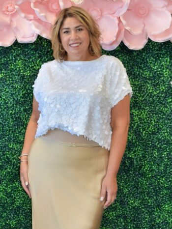 Front view of woman wearing white short sleeve sequin top with oversized shimmer detail – party-ready, size inclusive fit.