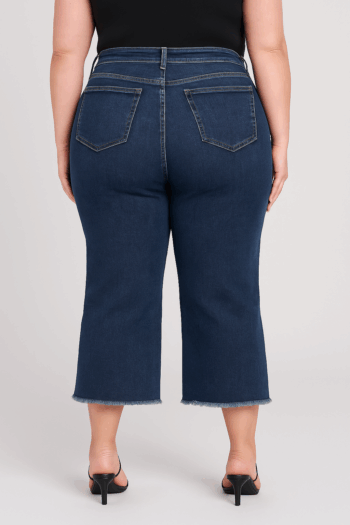 Back view of plus size RFM Chloe dark wash cropped jeans with frayed hem and patch pockets.