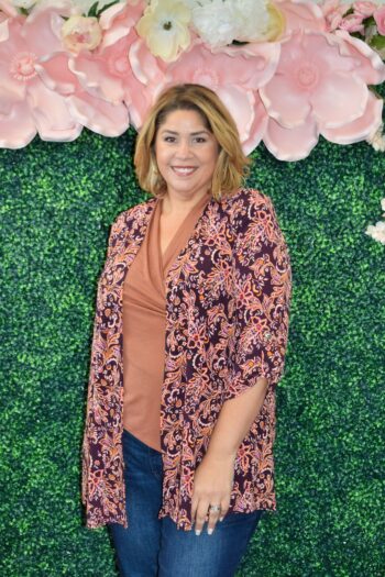 Plus size woman wearing a Dear Scarlett paisley print open-front cardigan in warm tones, styled with jeans and a neutral top.