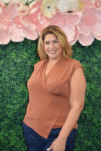 Woman wearing the Dear Scarlett Surplice Top in rust, featuring a crossover V-neckline and cap sleeves in wrinkle-free knit.