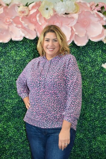 Front view of a plus size model wearing the Dear Scarlett Weekender Top in a navy and pink speckle print, featuring a cozy hood and relaxed fit.