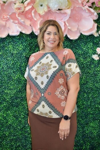 Front and back view of a plus-size floral chevron dolman sleeve top in rust, olive, and cream with a relaxed fit and off-shoulder style.