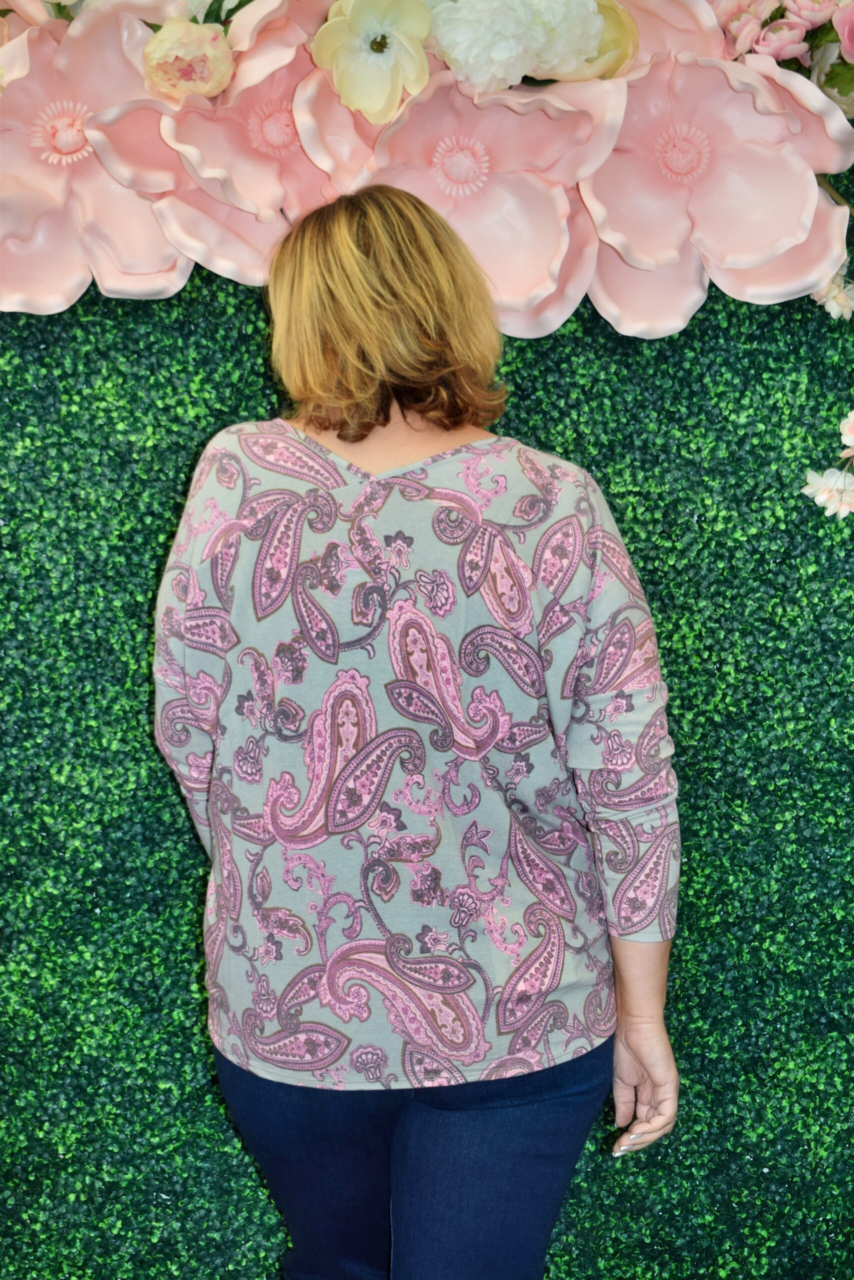 Back view of the Juliette Top showing the soft pink and gray paisley print, double V-neck detail, and easy-fit silhouette designed for plus size women.