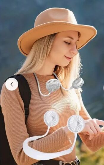 Woman wearing a portable neck fan outdoors with beige sweater and hat, showcasing lightweight hands-free design.
