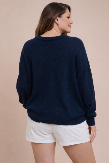 Back view of a navy lightweight American flag sweater on a mid-size model showing the relaxed fit and summer knit fabric.