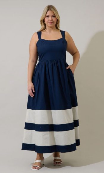 Mid-size woman in her late 40s wearing a navy and white plus size Nantucket midi dress with square neckline, wide straps, and striped hem.